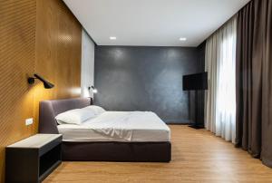 a bedroom with a bed and a black wall at Hotel La Favorita in Tirana