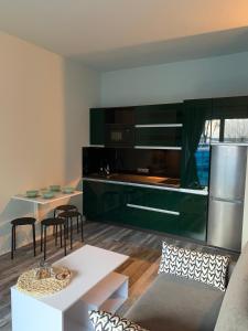 eine Küche mit grünen Schränken und einem weißen Tisch in der Unterkunft Aquarius002 in Ujazdowo