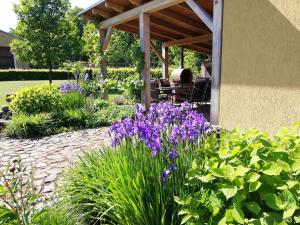 un jardín con flores púrpuras junto a una casa en Pension Rothschildův dvůr, en Bělá