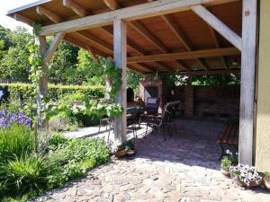 a wooden pergola with a table and chairs on a patio at Pension Rothschildův dvůr in Bělá