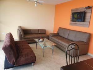 a living room with two couches and a table at Tonsupa-Edificio MIRASOL in Tonsupa