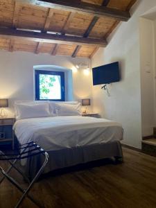 a bedroom with a large bed with a tv on the wall at Relais FraSimon Antico Casale in San Vito Chietino
