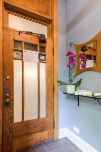 a wooden door in a room with a potted plant at House 5863- Chicago's Premier Bed and Breakfast in Chicago