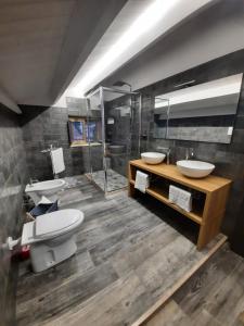 ein Badezimmer mit zwei Waschbecken, einem WC und einer Dusche in der Unterkunft Beach apartments in Campomarino