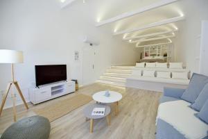 a living room with a couch and a tv at Hydra Hospitality Port Apartment in Hydra