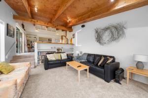a living room with a couch and a table at Stroll to the Sea - Te Horo Beach Holiday House in Te Horo