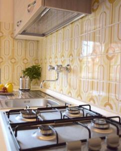 a kitchen with a stove top oven in a kitchen at Seafront apartment 2 in Villa near Rome in Torvaianica