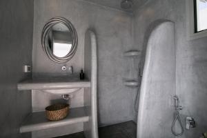 y baño con lavabo y espejo. en Sensia Luxury Apartment with Hot tub, en Oia