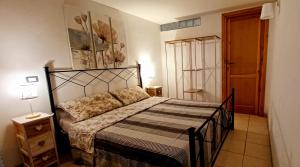1 dormitorio con 1 cama con marco negro en Casa di Zio, en Alghero