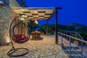 eine Terrasse mit einem Tisch und Stühlen unter einer Pergola in der Unterkunft Villa Navagio Volimes in Volímai