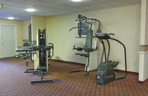 Express Airport Inn في ساندستون: صالة ألعاب رياضية مع جهازين في الغرفة
