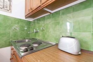 a kitchen with a stove and a toaster on a counter at Apartment Kukljica 7 in Kukljica +29 photos