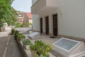 eine Terrasse mit Pflanzen und einen Pool auf einem Gebäude in der Unterkunft Apartments Dilk in Vis