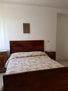 1 dormitorio con 1 cama grande y cabecero de madera en Holiday House a Firmo, en Firmo