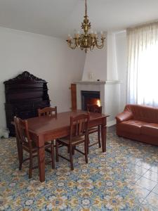 sala de estar con mesa, sofá y chimenea en Holiday House a Firmo, en Firmo