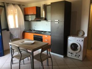 ヴァッレドーリアにあるResidence Valledoria 2のキッチン(テーブル、洗濯機付) +3枚の写真