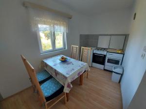 een kleine keuken met een tafel en een tafel met stoelen bij Apartment Dora in Draga Bašćanska