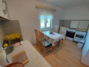 een keuken met een tafel met stoelen en een keuken met een fornuis bij Apartment Dora in Draga Bašćanska +7 foto's