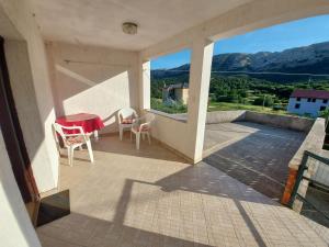een balkon met een tafel en stoelen en uitzicht bij Apartment Dora in Draga Bašćanska