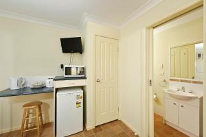 a small kitchen with a white refrigerator and a sink at Mudgee Valley Park in Mudgee +53 photos
