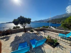 a patio with blue chairs and a view of the water at Apartments Mitrovići Miločer in Sveti Stefan