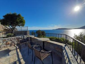 a patio with chairs and a view of the water at Apartments Mitrovići Miločer in Sveti Stefan