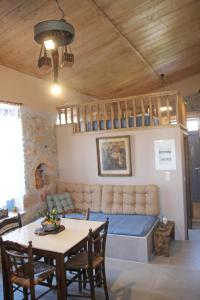 ein Wohnzimmer mit einem Bett und einem Tisch in der Unterkunft Laini Guest Houses in Koulkouthianá