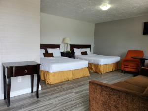 a hotel room with two beds and a chair at Wiarton Willys Inn in Wiarton