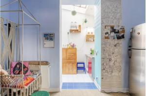 a room with a baby crib and a kitchen at Charmante chambre double chez l'habitant in Pantin