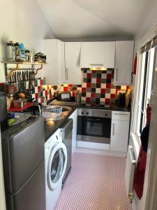 uma cozinha com uma máquina de lavar roupa e uma máquina de lavar roupa em Little Gem with Private Hot Tub - Up to 25 percent off ferry em Shanklin