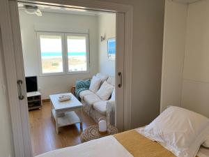 Apartamento Canaleta Aitana frente al mar في بونتا أومبريا: غرفة نوم مع سرير وغرفة معيشة مع أريكة