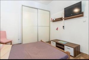 a bedroom with a bed and a flat screen tv at Two Room Eva in Pula