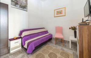 a bedroom with a purple bed and a pink chair at Two Room Eva in Pula
