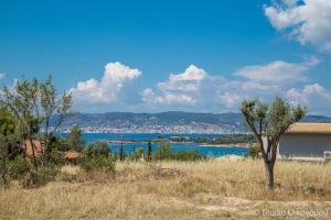 vista su una cassa d'acqua con un edificio e alberi di Studio Gerani 2 a Porto Heli