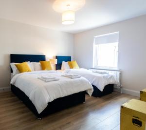 a bedroom with two beds with yellow pillows at Hilltown Lodge No3 in Hilltown