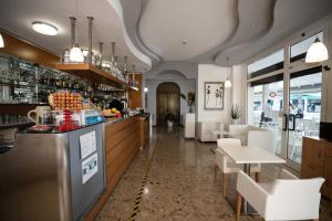 un ristorante con un bar, un tavolo e delle sedie di Hotel Eraclea a Lido di Jesolo