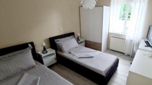 Habitación pequeña con 2 camas y ventana en NAT Apartments en Koper