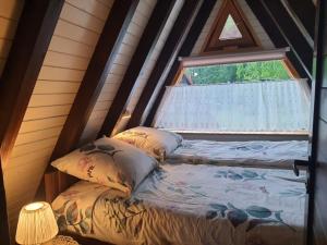 łóżko w pokoju z oknem w obiekcie Domek letniskowy Julia w mieście Ińsko