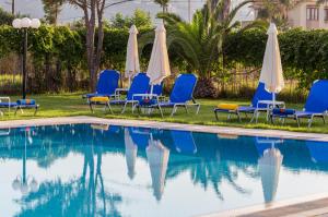 eine Gruppe von Stühlen und Sonnenschirmen neben einem Pool in der Unterkunft Alonia Hotel Apartments in Kolimvárion