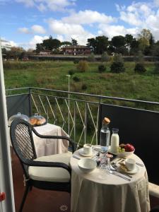 a table and chairs on a balcony with a view of a field at Unicum Roma Suites in Rome