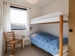 ein Schlafzimmer mit einem Etagenbett und einem Stuhl in der Unterkunft 5 person holiday home in Fanø in Fanø