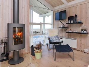 フレデリクスハウンにある6 person holiday home in Frederikshavnのリビングルーム(暖炉、椅子付)