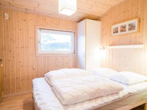 ヘンネ・ストランドにある6 person holiday home in Henneの木製の壁に白いベッドが備わるベッドルーム1室