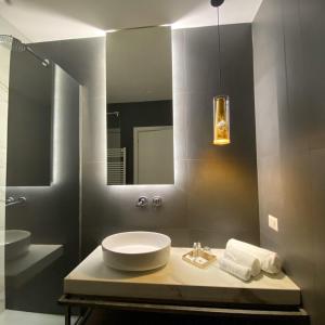 a bathroom with a sink and a mirror at Unicum Roma Suites in Rome