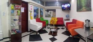 a waiting room with colorful chairs and a tv at Hotel Xilon Resort Plaza in Pasto