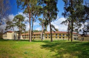 an exterior view of a building with trees at Waldhotel am See Berlin-Schmöckwitz in Berlin