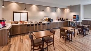 a kitchen with wooden tables and chairs and a counter at Best Western Plus Jefferson in Jefferson