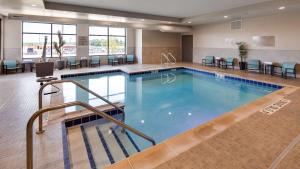 a pool in a hotel room with chairs and tables at Best Western Plus Jefferson in Jefferson