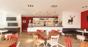 a restaurant with tables and chairs and a bar at Sure Hotel by Best Western Muenchen Hauptbahnhof in Munich