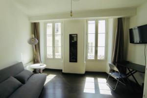 un salon avec un canapé et quelques fenêtres dans l'établissement Grand studio à deux pas du Vieux Port, à La Rochelle